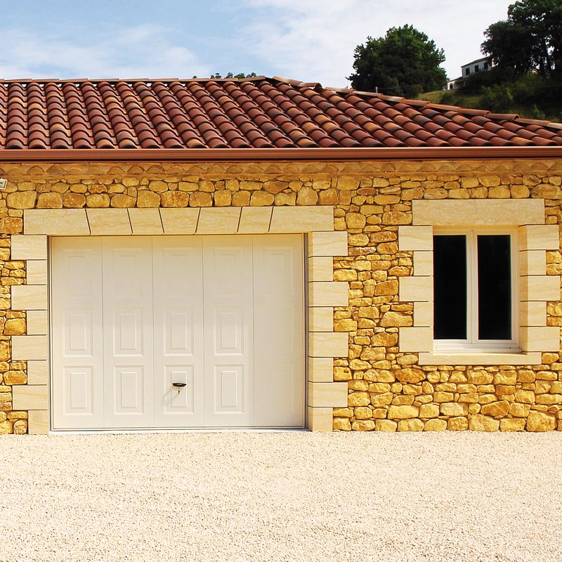 Garage en pierre naturelle à Mérignac avec encadrements en pierre calcaire taillée, finition soignée et style traditionnel.