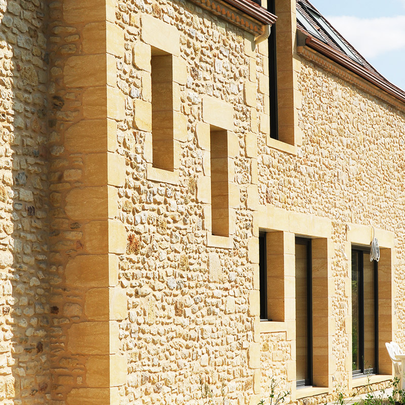 Façade rénovée en pierre calcaire à Mérignac, avec encadrements sur mesure pour fenêtres et portes, alliant élégance et authenticité.